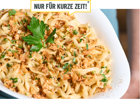 Eine Person hällt eine Schale mit der Pasta in die Kamera.