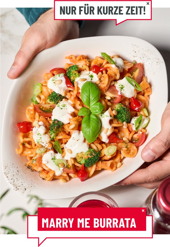 Eine Person hällt eine Schale mit der Burrata-Pasta in die Kamera.