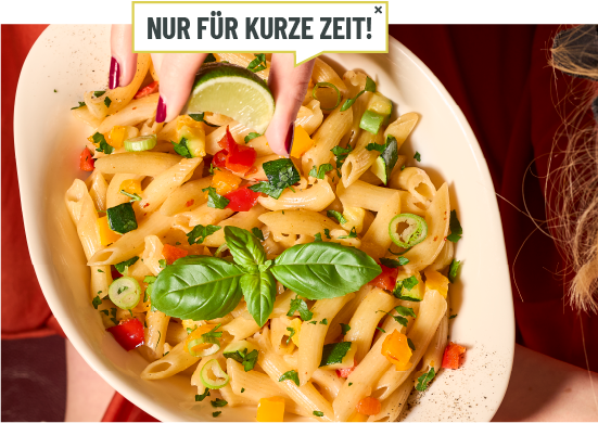 Eine Person hällt eine Schale mit der Pasta in die Kamera.